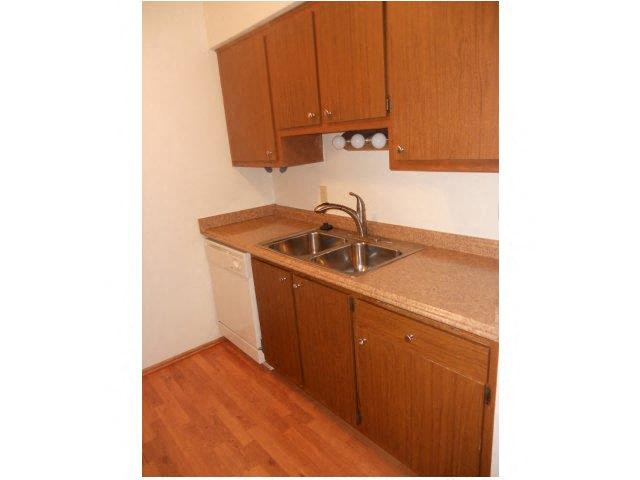 a small kitchen with a sink and wooden cabinets