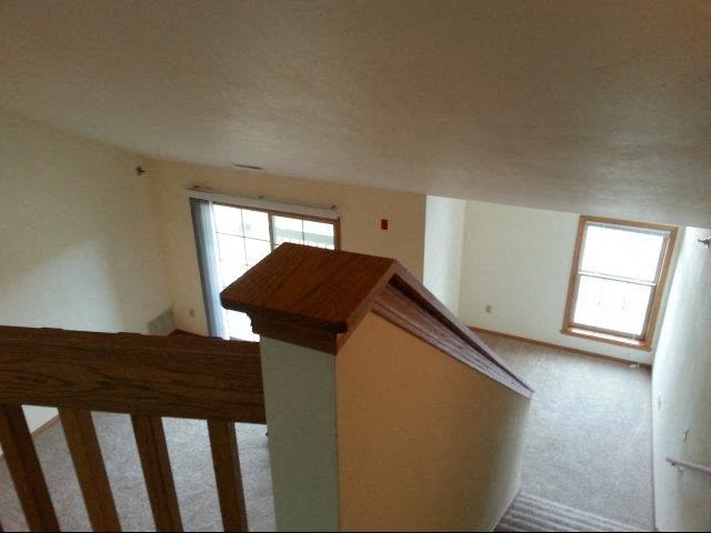 an empty room with a staircase and a window