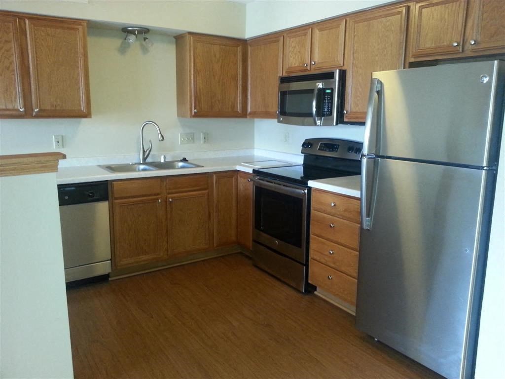 a kitchen with stainless steel appliances and wooden cabinets