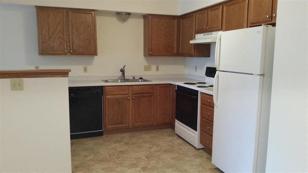 a kitchen with a white refrigerator and a sink