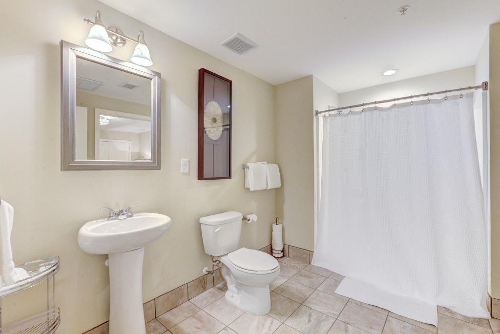 a bathroom with a white shower curtain and a toilet and a sink