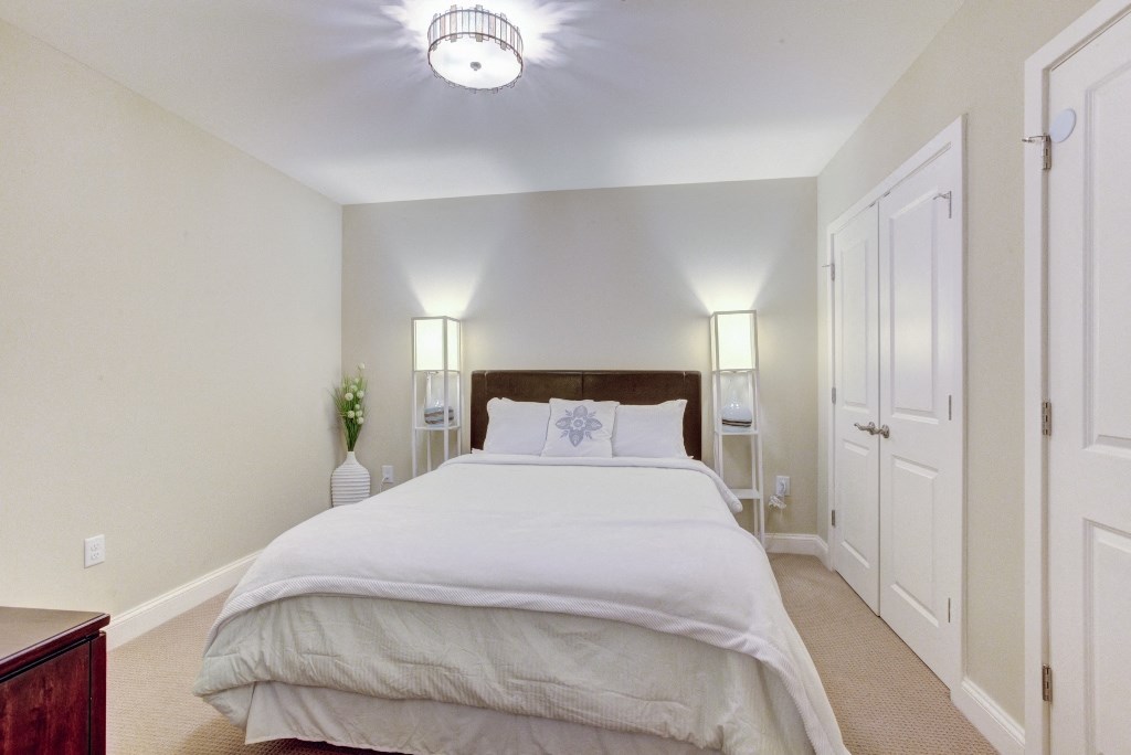a bedroom with a large white bed and a closet