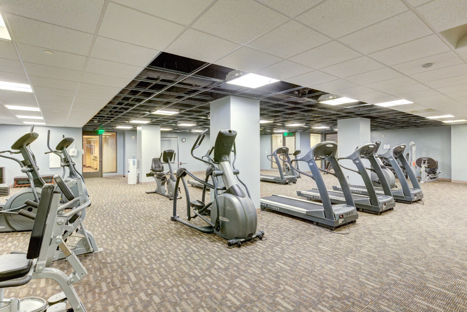 a gym with various cardio equipment in a building