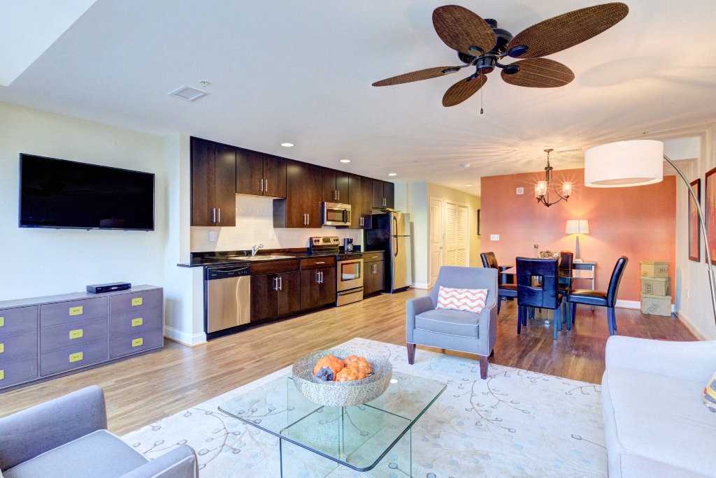 a living room and kitchen with a ceiling fan