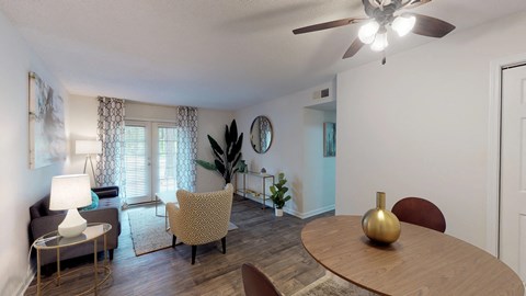A living room with a wooden table and a ceiling fan.