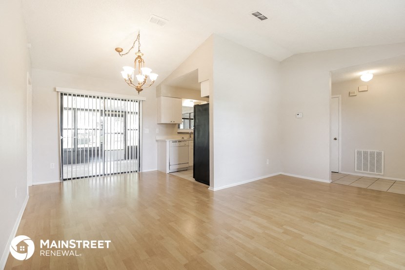 the living room and dining room of an apartment with wood flooring