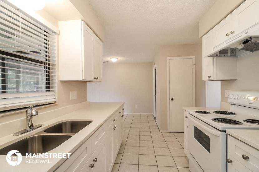 a white kitchen with a stove and a sink
