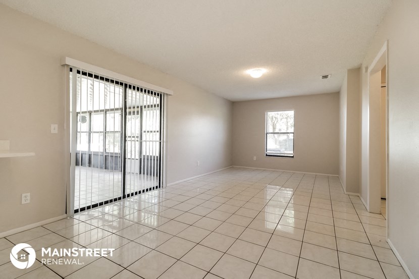 a spacious living room with tile flooring and a large window
