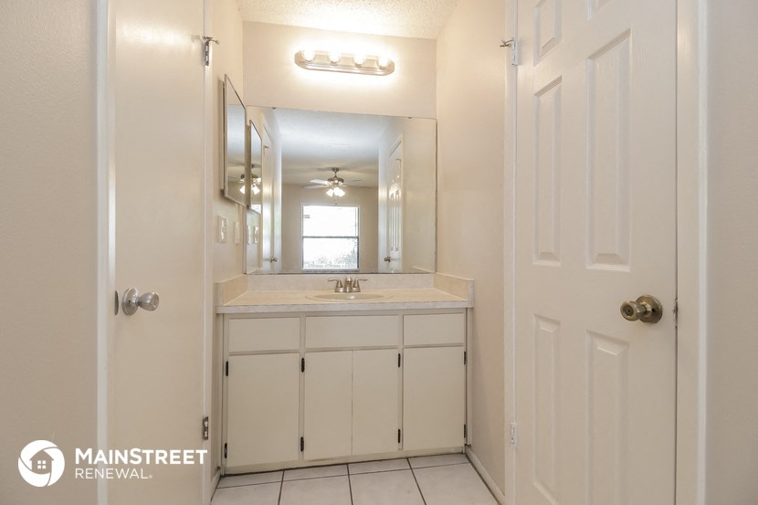 a white bathroom with a sink and a mirror