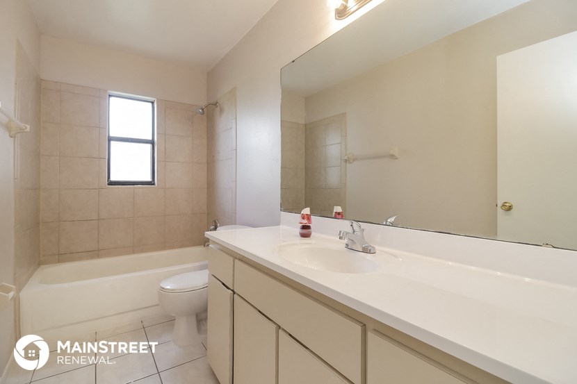 a bathroom with a large mirror and a sink and a toilet