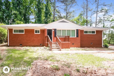 a small brick house with a porch and stairs