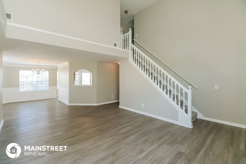 the spacious living room and dining room with staircase to the second floor