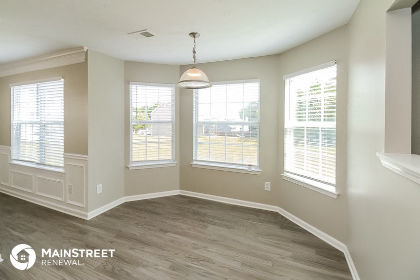 the living room of a new home with wood flooring and windows