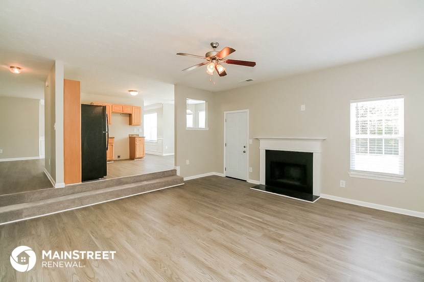 a living room with a fireplace and a ceiling fan