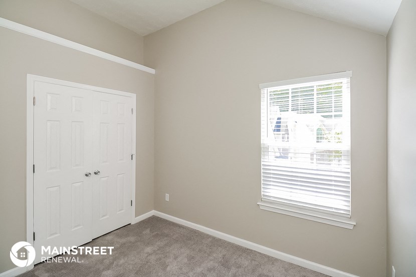 a bedroom with a closet and a door and a window