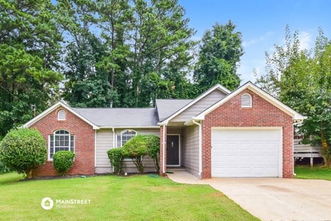 a brick house with a white garage door and a lawn