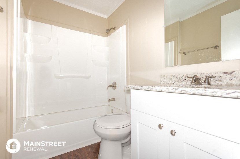 a white bathroom with a shower and a toilet