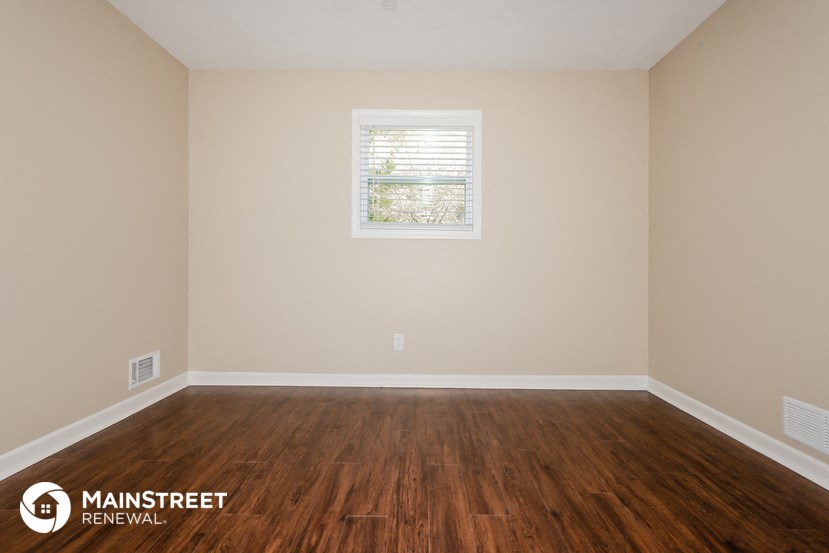 a room with wooden floors and a window