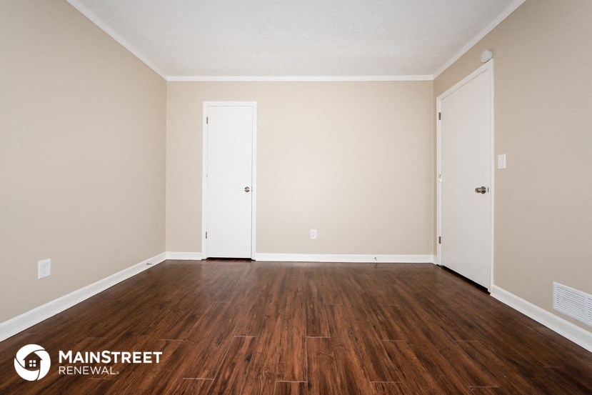 the interior of an empty room with wood floors and white walls