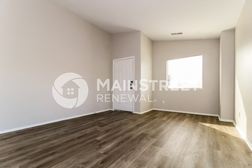 renovated living room with hardwood flooring and a window