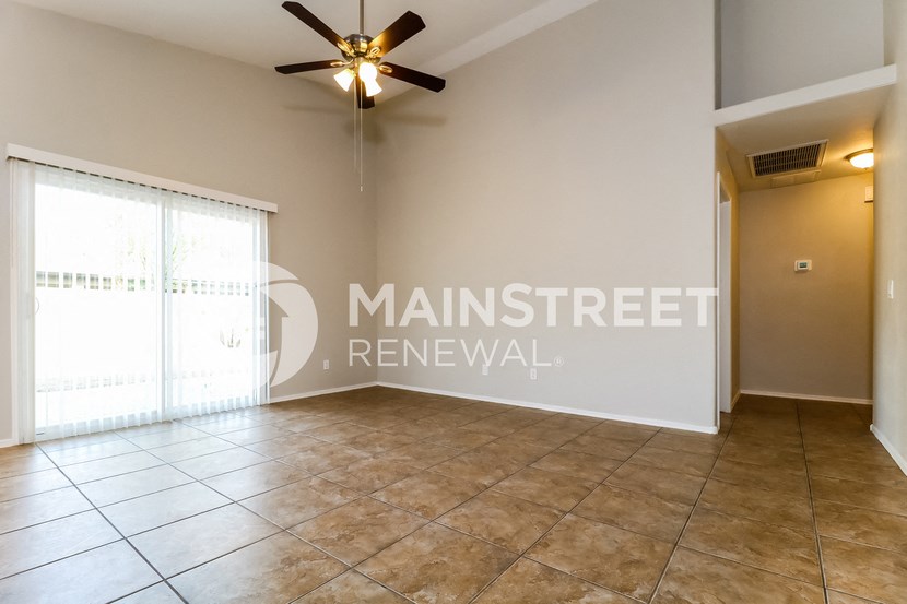 a living room with tile floor and a ceiling fan