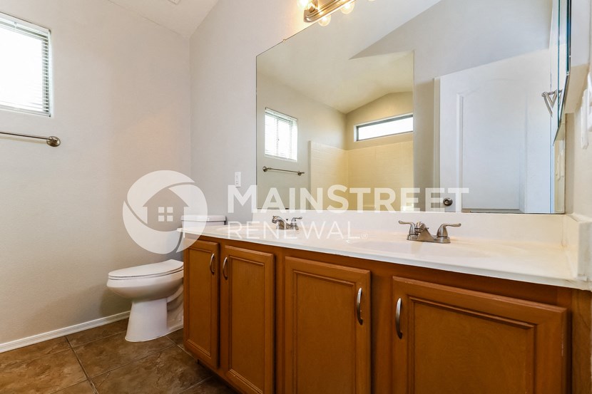 a bathroom with a toilet and a sink and a mirror