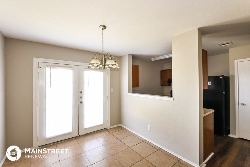 a dining room with two doors and a chandelier