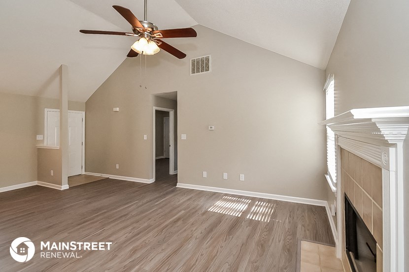the living room with fireplace and ceiling fan