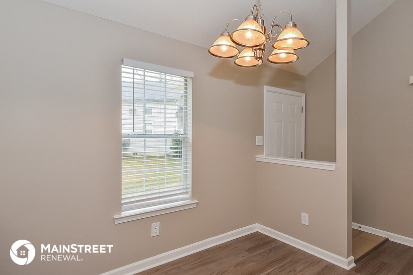 the living room of a home with a window and a light fixture