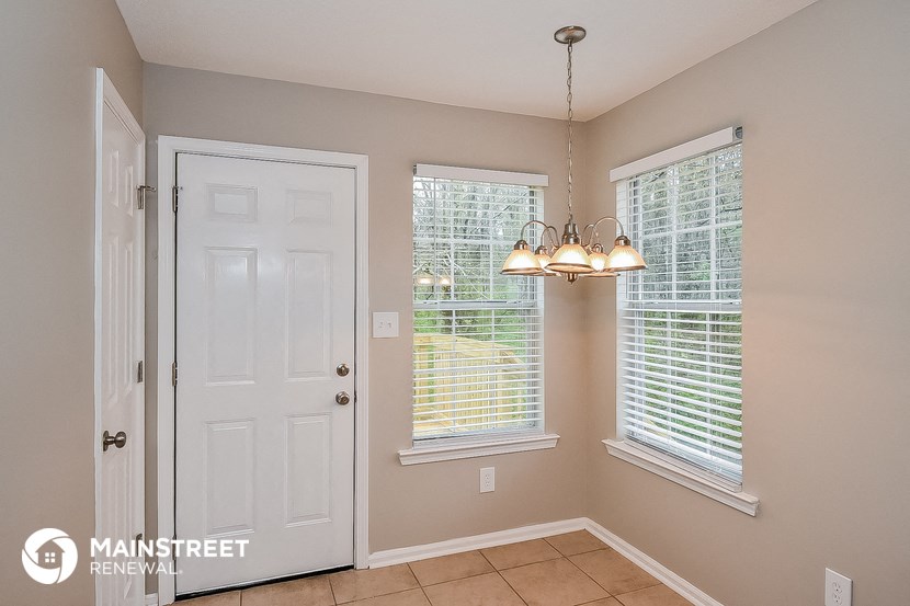 the entryway of a home with two windows and a white door