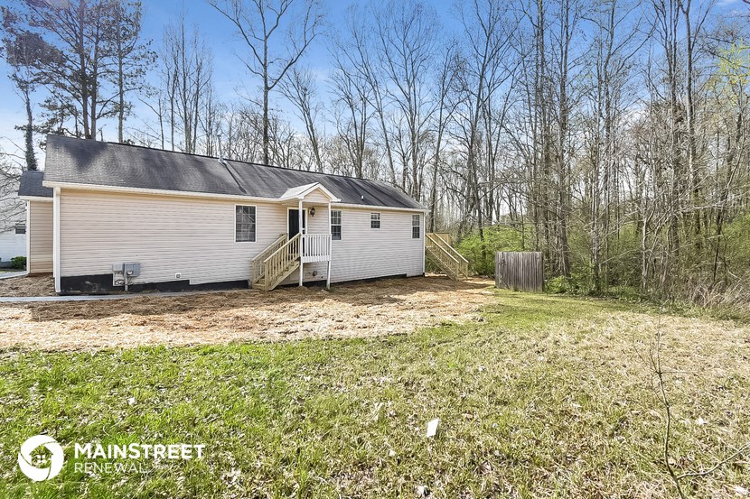 a small white house on the side of a field