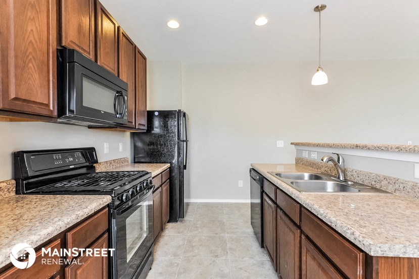 a kitchen with wood cabinets and black appliances and granite counter tops