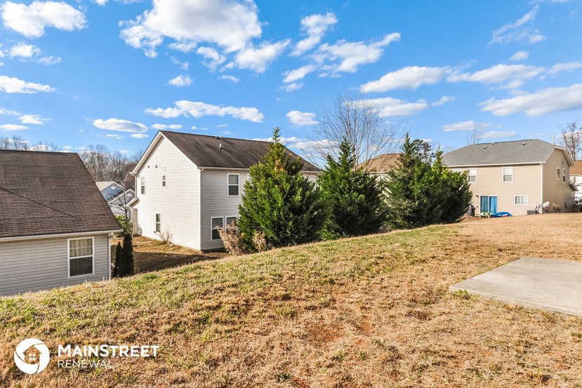 a view of three houses on a hill with a blue sky