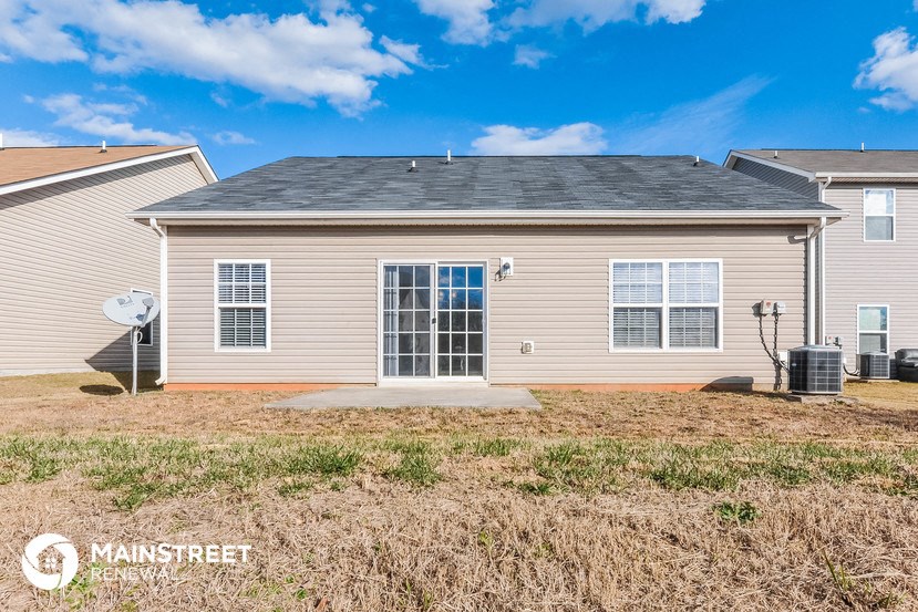 a small tan house with a yard in front of it