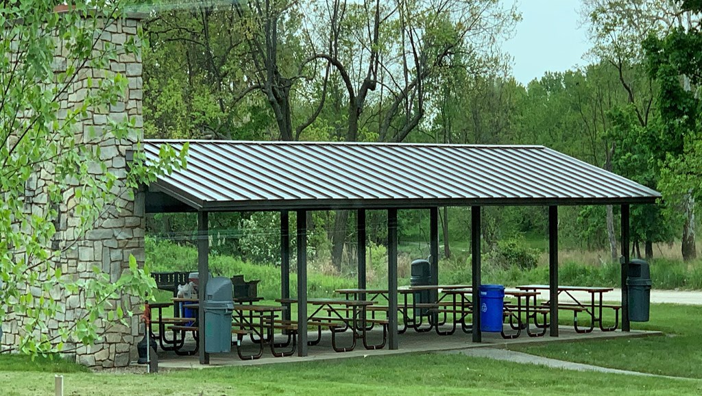 a pavilion with picnic tables in a park