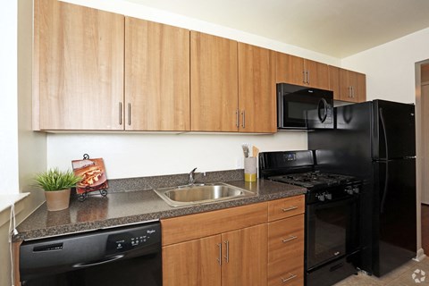 a kitchen with black appliances and a granite counter top