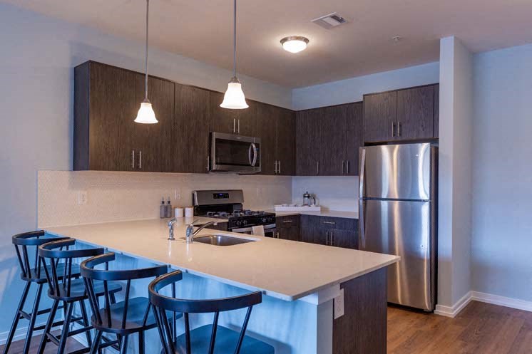 a kitchen with a counter top and a stainless steel refrigerator