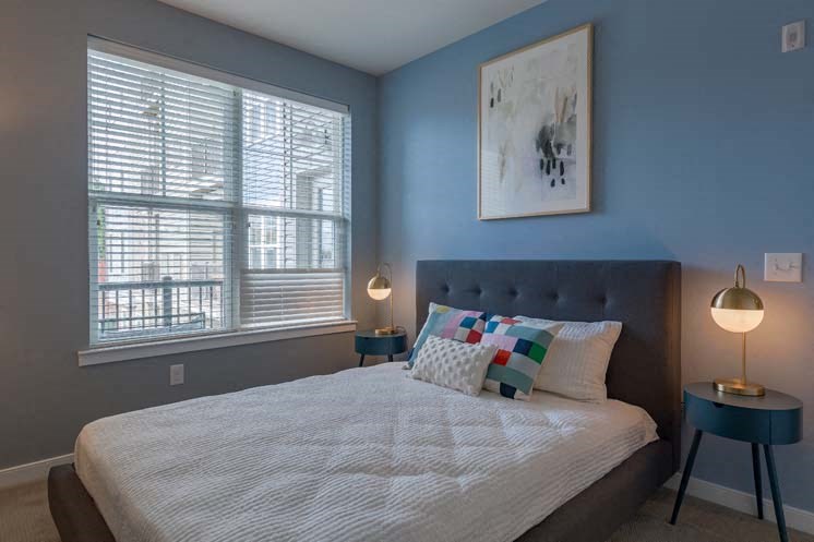 a bedroom with a bed and a large window