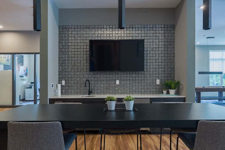 a kitchen with a table and chairs and a tv on the wall