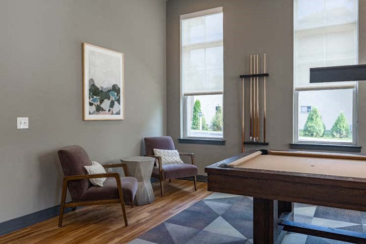 a room with a pool table and two chairs