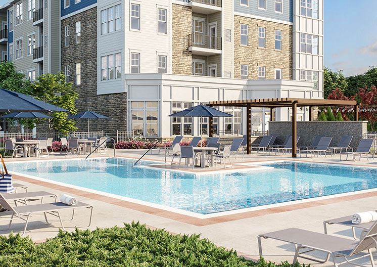 a swimming pool with chairs and umbrellas in front of a building