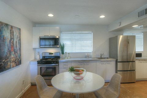 a kitchen with white cabinets and a table