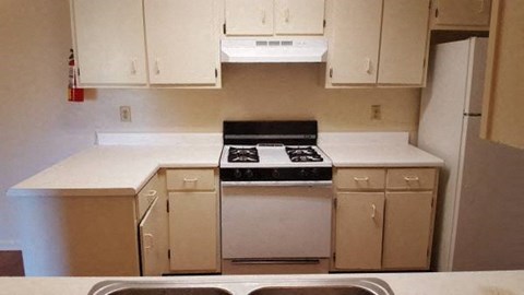 A white kitchen with a black stove top oven.