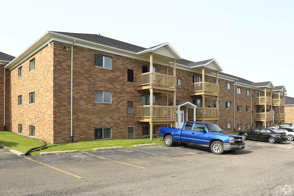 a blue truck parked in front of an apartment building