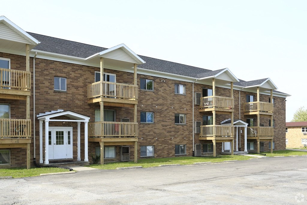 an exterior view of a brick apartment building with balconies