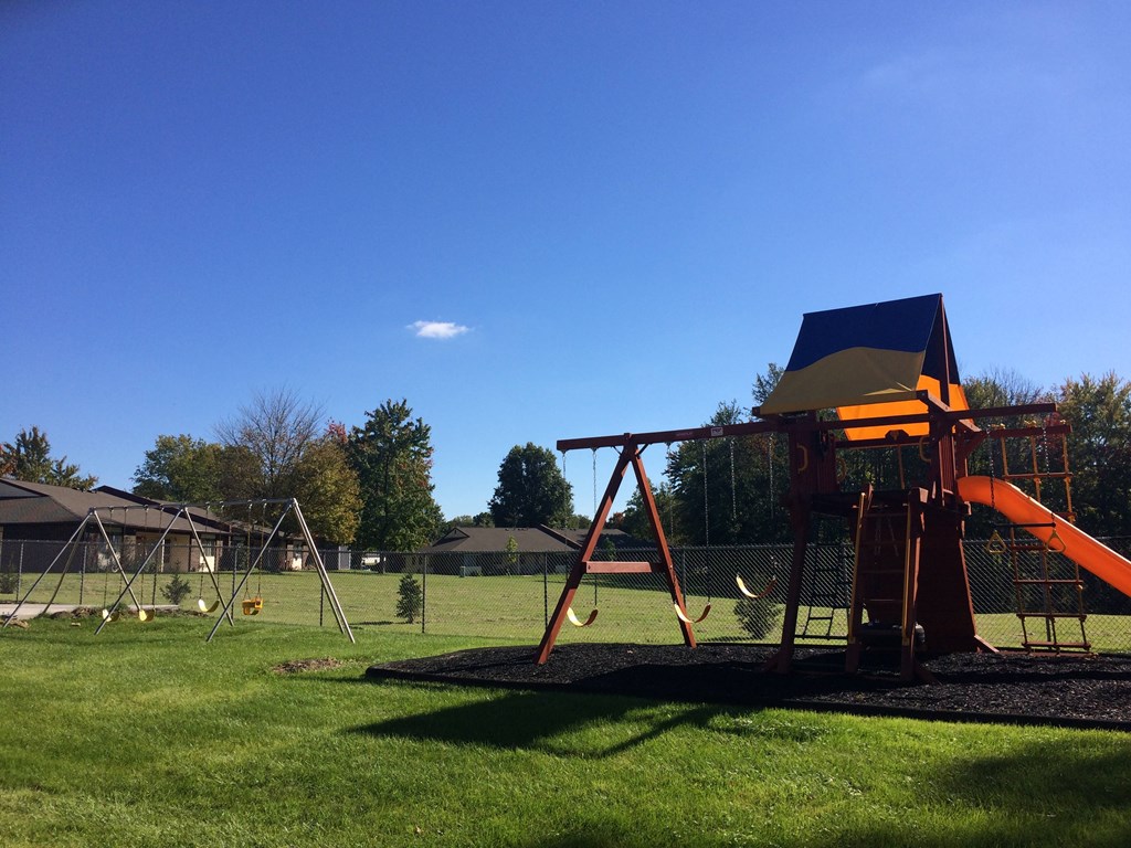 a playground with a swing set on a sunny day