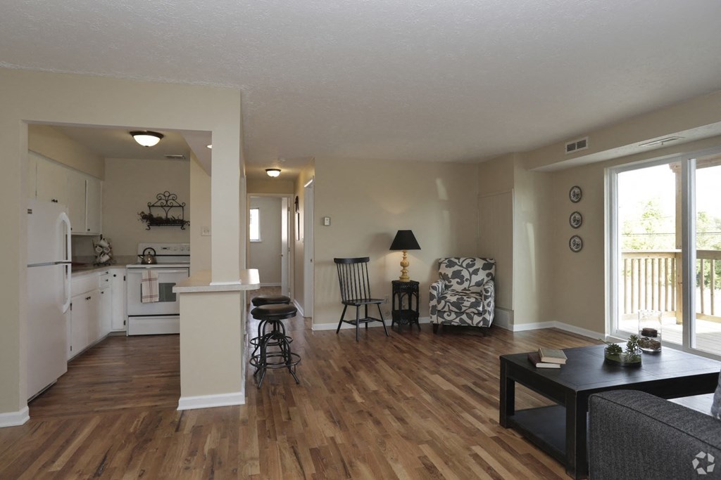 the view of a living room and kitchen with a wood floor
