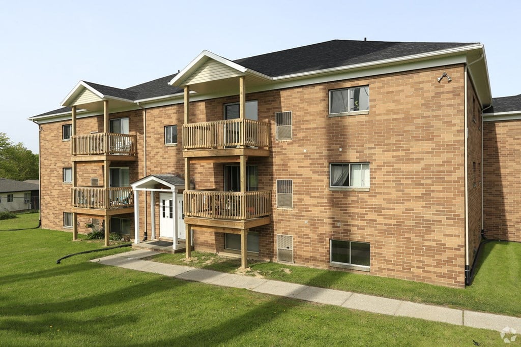 an exterior view of a brick apartment building with balconies