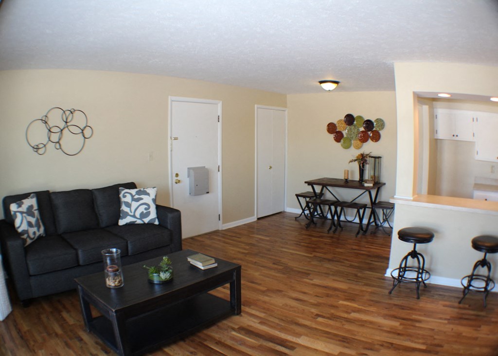 a living room with a couch and a coffee table in front of a dining room