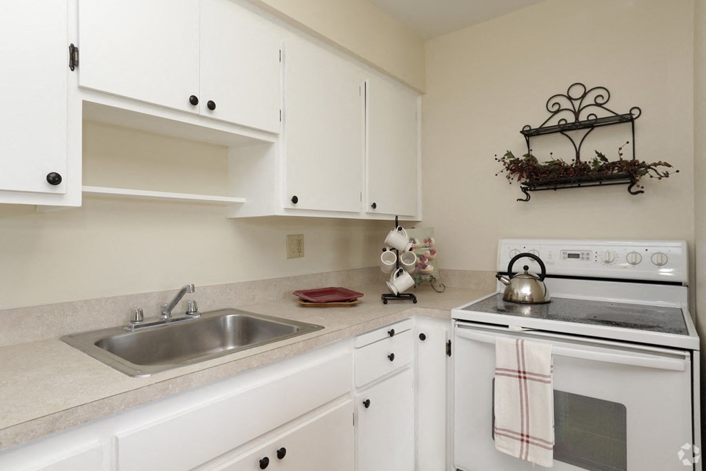 a kitchen with white cabinets and appliances and a sink